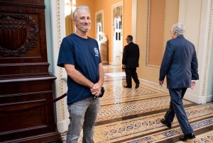Jon Stewart laughs as Mitch McConnell walks by